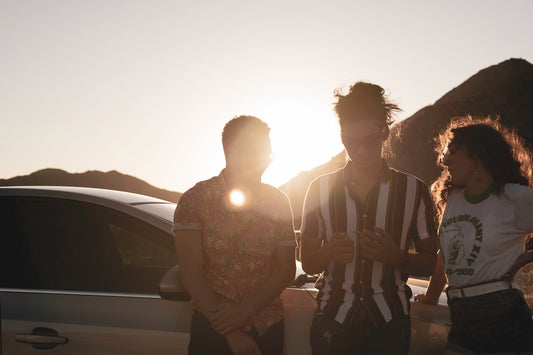 3 women sitting on car