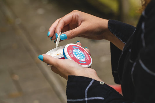person holding blue and white plastic cup