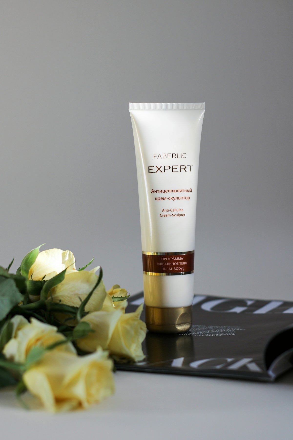 a close up of a tube of cream next to flowers