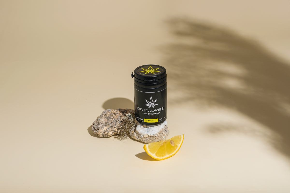 a bottle of cb sitting on top of a rock next to a lemon