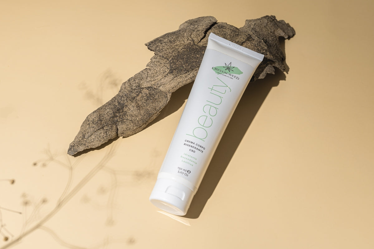 a tube of toothpaste sitting next to a leaf