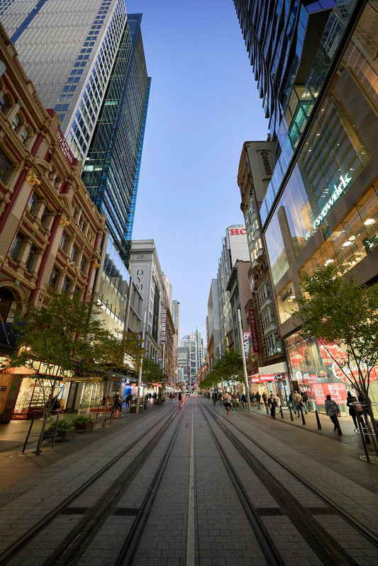 a city street lined with tall buildings and people walking