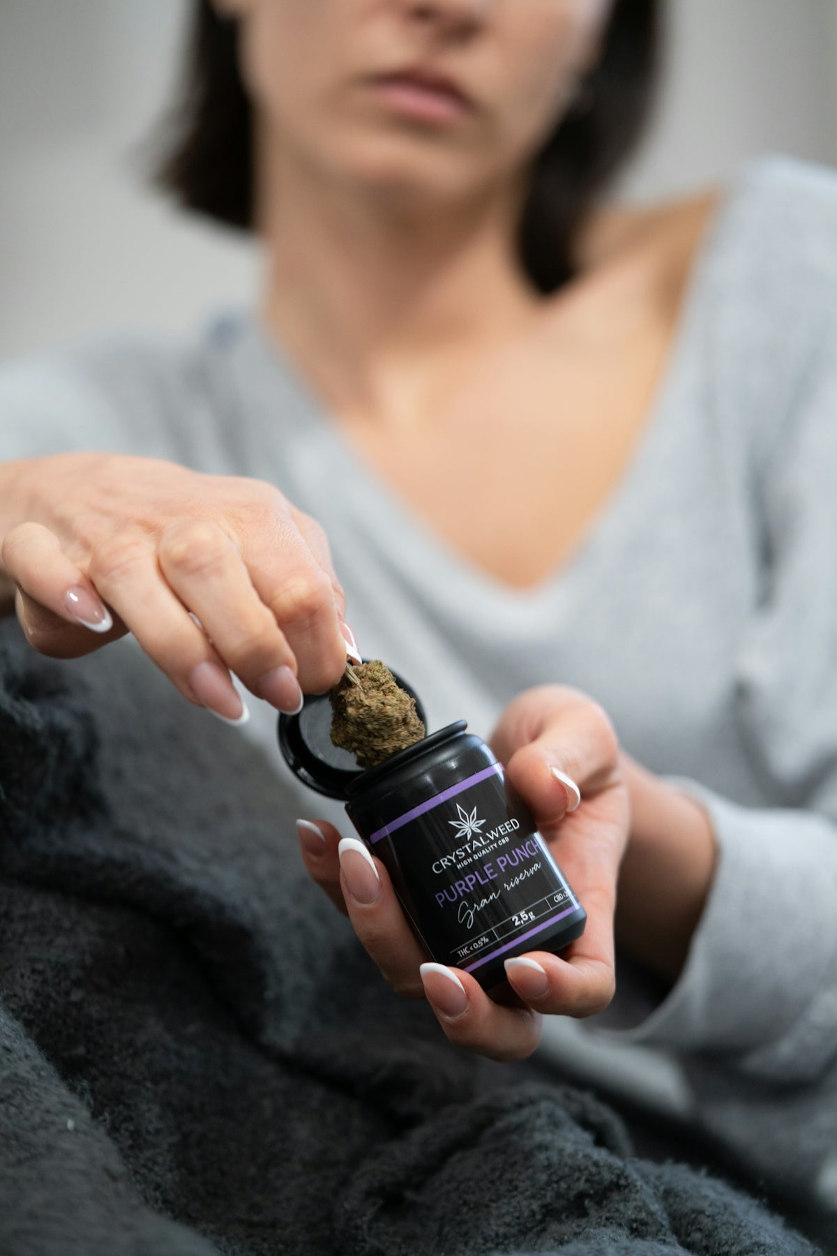 a woman holding a small bottle of cbd