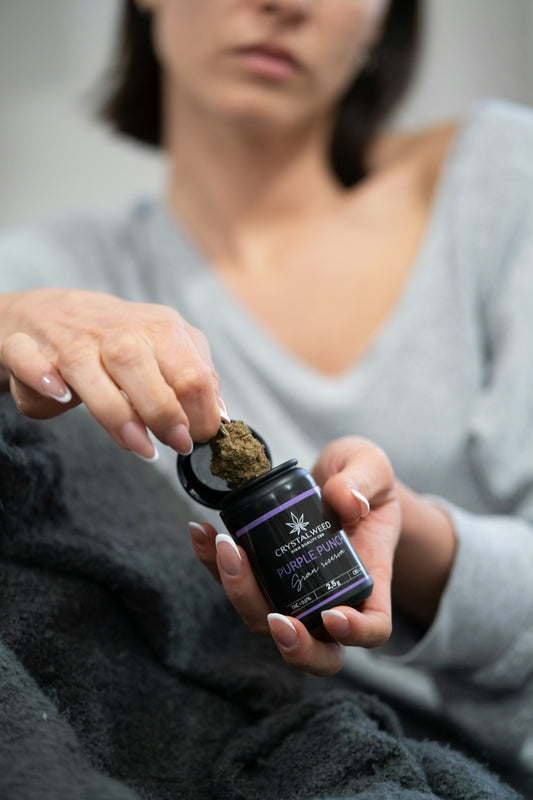 a woman holding a small bottle of cbd
