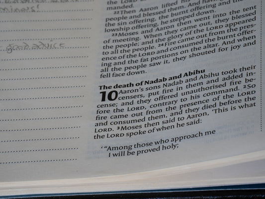 Close-up of a bible page with text and headings.