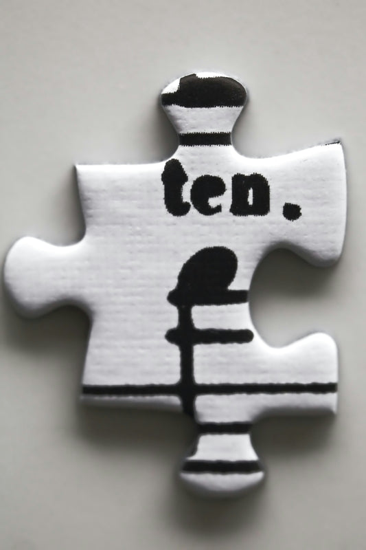 A white puzzle piece with the word ten. on it.
